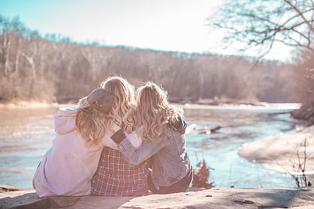 three woman sitting beside river thumbnail