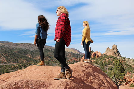 three women standing on mountain cliff during daytime thumbnail