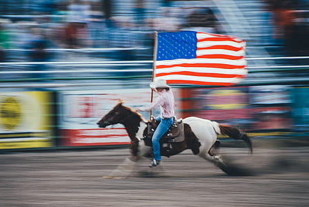 time lapse photography of cowboy riding on brown and white horse while running on the field thumbnail