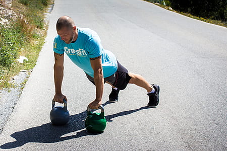person holding kettle bells on the ground thumbnail