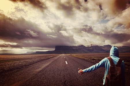 person wearing blue hoodie standing on gray pavemnet thumbnail