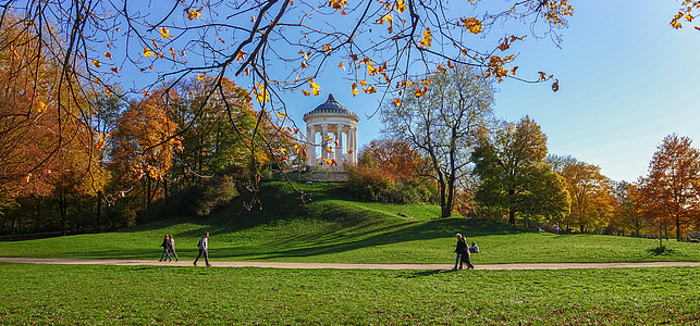 people walking in the park near white concrete building at daytime thumbnail