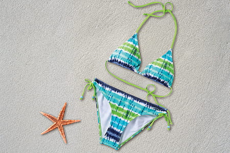 women's blue-and-green halter bikini on beige sand near starfish thumbnail