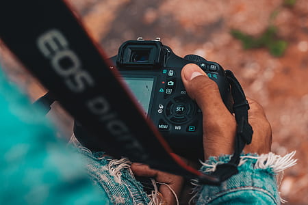 person holding black Canon EOS camera thumbnail