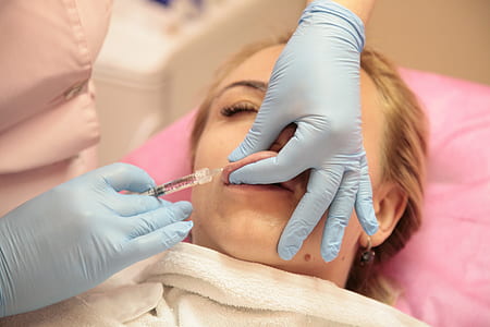 person holding syringe injecting on woman's lip thumbnail