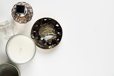 gold-colored and white gemstone pendant necklace with case near white candle and perfume bottle thumbnail