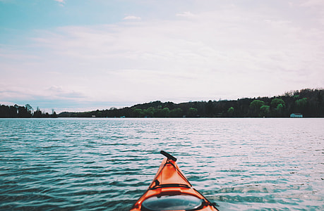 orange kayak on body of water during daytime thumbnail