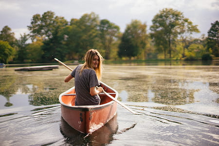 woman rowing on red wooden canoe thumbnail