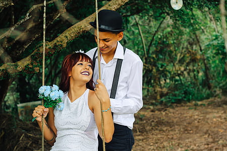 woman riding swing in front of man thumbnail