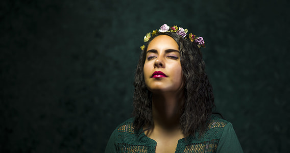 woman closing her eyes standing against black background thumbnail