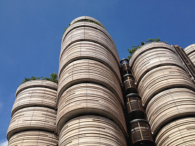 low angle photo of a brown concrete high-rise building under blue sky thumbnail