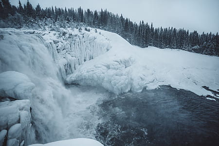 person taking photo of falls covered with snow thumbnail