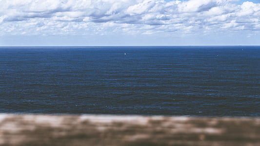 calm body of water under white clouds thumbnail