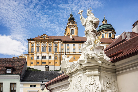 low angle photo of man holding cross statue thumbnail