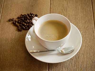 white ceramic cup filled with coffee and saucer thumbnail