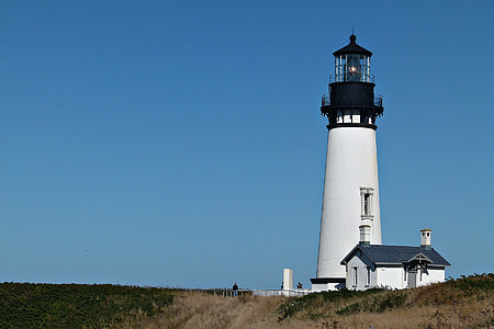 photo of white and black concrete lighthouse under clear blue sky thumbnail
