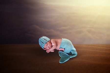 baby in teal knit cap and mermaid tail bottoms thumbnail