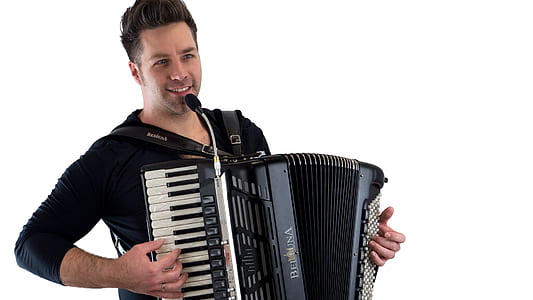 man singing in microphone while playing accordion thumbnail