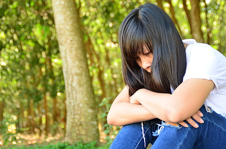 woman siting under forest trees thumbnail