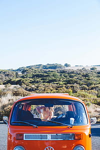 orange Volkswagen T2 van near hill thumbnail