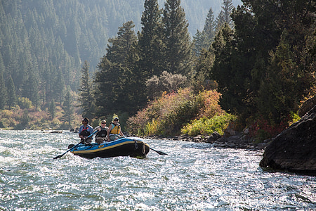 three person on inflatable boat on river beside trees at daytime thumbnail