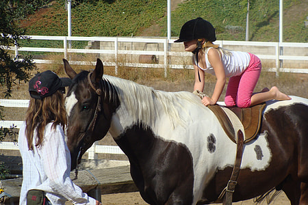 girl sitting on top of horse's back in front of woman standing thumbnail