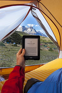 person holding black e-book reader inside tent thumbnail