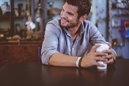 man sitting on chair holding white tumbler thumbnail