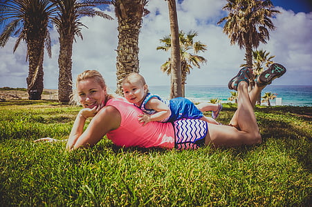 woman wearing pink tank top with baby on the back thumbnail
