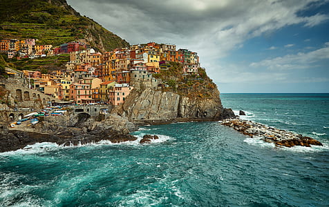 houses on cliff by the shore during daytime thumbnail