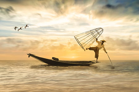 man standing on brown boat using left foot thumbnail