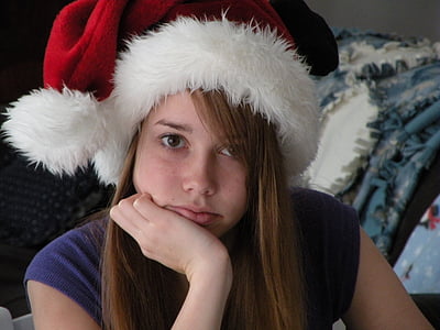 woman taking selfie while wearing santa hat thumbnail