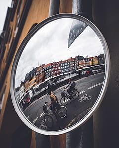 reflection of two person riding on bike on clear glass mirror thumbnail