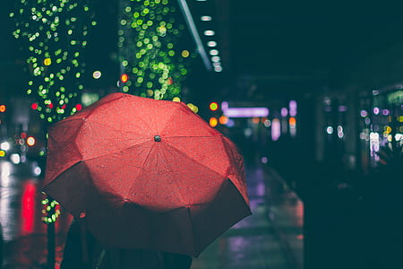 person using red umbrella with bookeh lights photography thumbnail