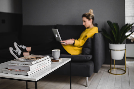Young woman sitting on the sofa and working on her laptop thumbnail