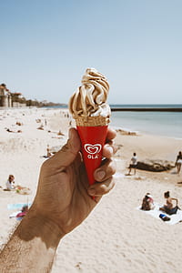 selective focus photography of person holding ice cream cone thumbnail