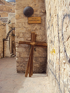 brown wooden cross leaning on brown wall thumbnail