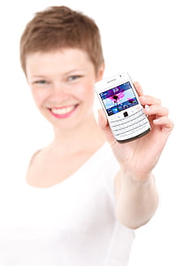 smiling woman holding white BlackBerry QWERTY phone thumbnail