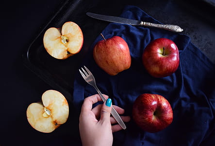 flat lay photography of man holding fork surrounded by sliced apples thumbnail