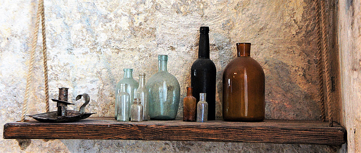 glass bottles on brown wooden floating shelf thumbnail