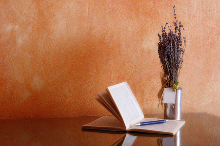 notebook with pen near silver vase on top of table thumbnail