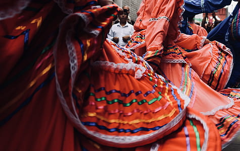 person wearing orange and green long-sleeved dress thumbnail
