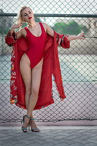 woman wearing red one-piece swimwear with red floral robe near gray metal fence thumbnail