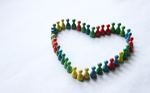 multicolored bowling pin forming heart on white surface thumbnail