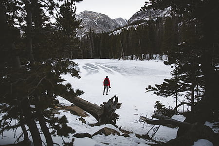 man standing on forest covered with snow during daytime thumbnail
