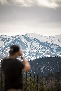 man looking on mountain covered with snow thumbnail
