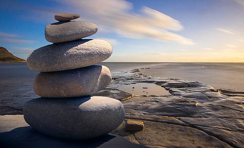 stack of grey rocks near brown surface under blue sky thumbnail