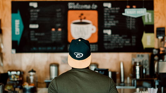 back view of man facing menu board thumbnail