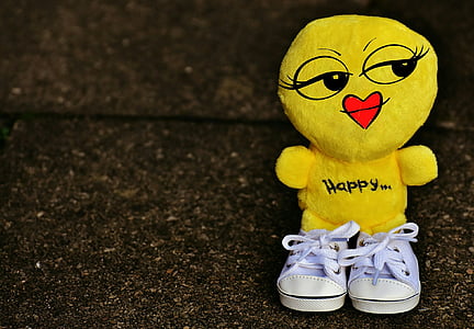 yellow plush toy with teal sneakers close-up photo thumbnail