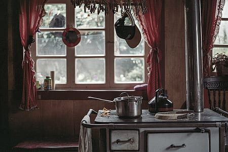 white and brown wood burner stove with cooking wares near window thumbnail